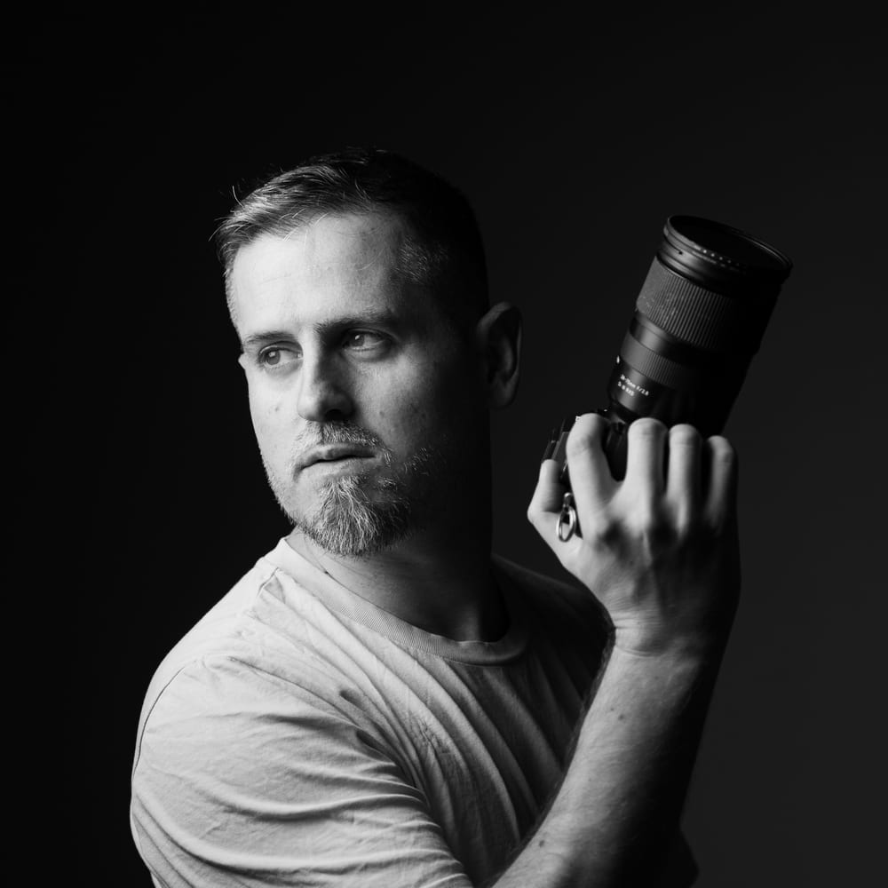Portrait of Eric from Objectiu Fotògrafs holding a camera