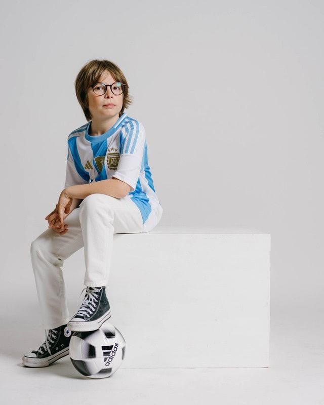 Niño con camiseta de fútbol y el balón a los pies en una sesión de comunión · Objectiu Fotògrafs, Reus