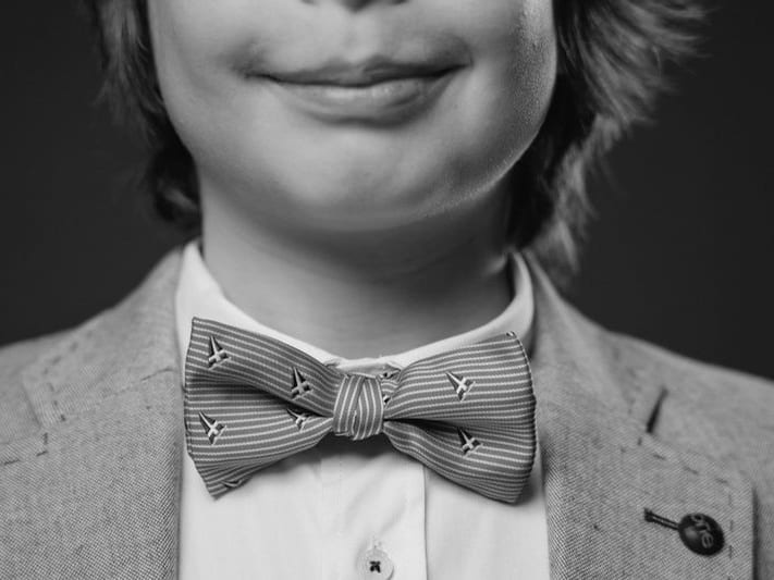 Detalle en blanco y negro de un niño sonriente con pajarita · Objectiu Fotògrafs, Reus
