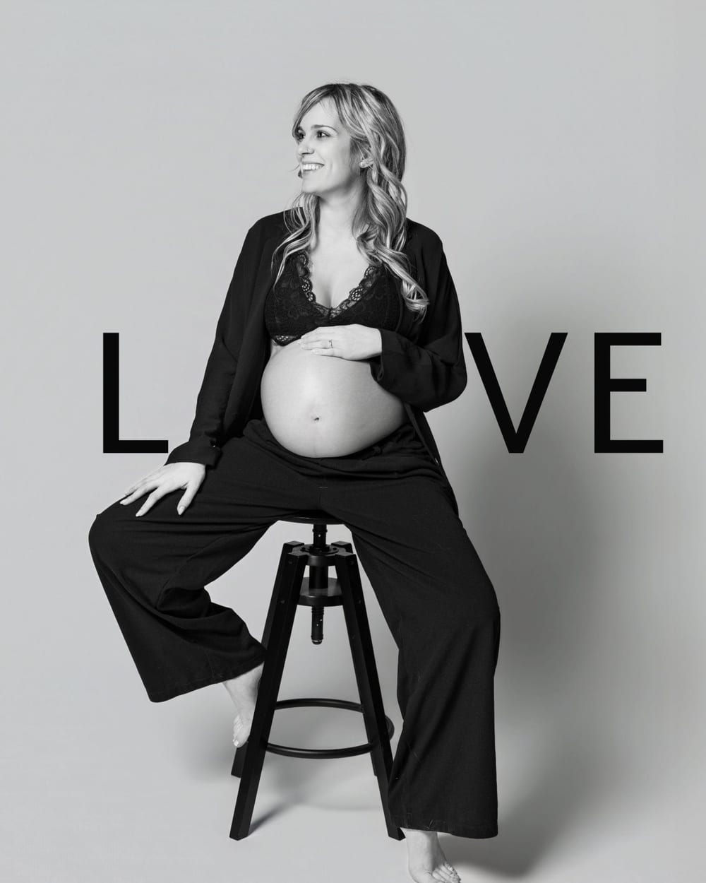 Pregnant woman between the letters LOVE, in black and white · Objectiu Fotògrafs, Reus