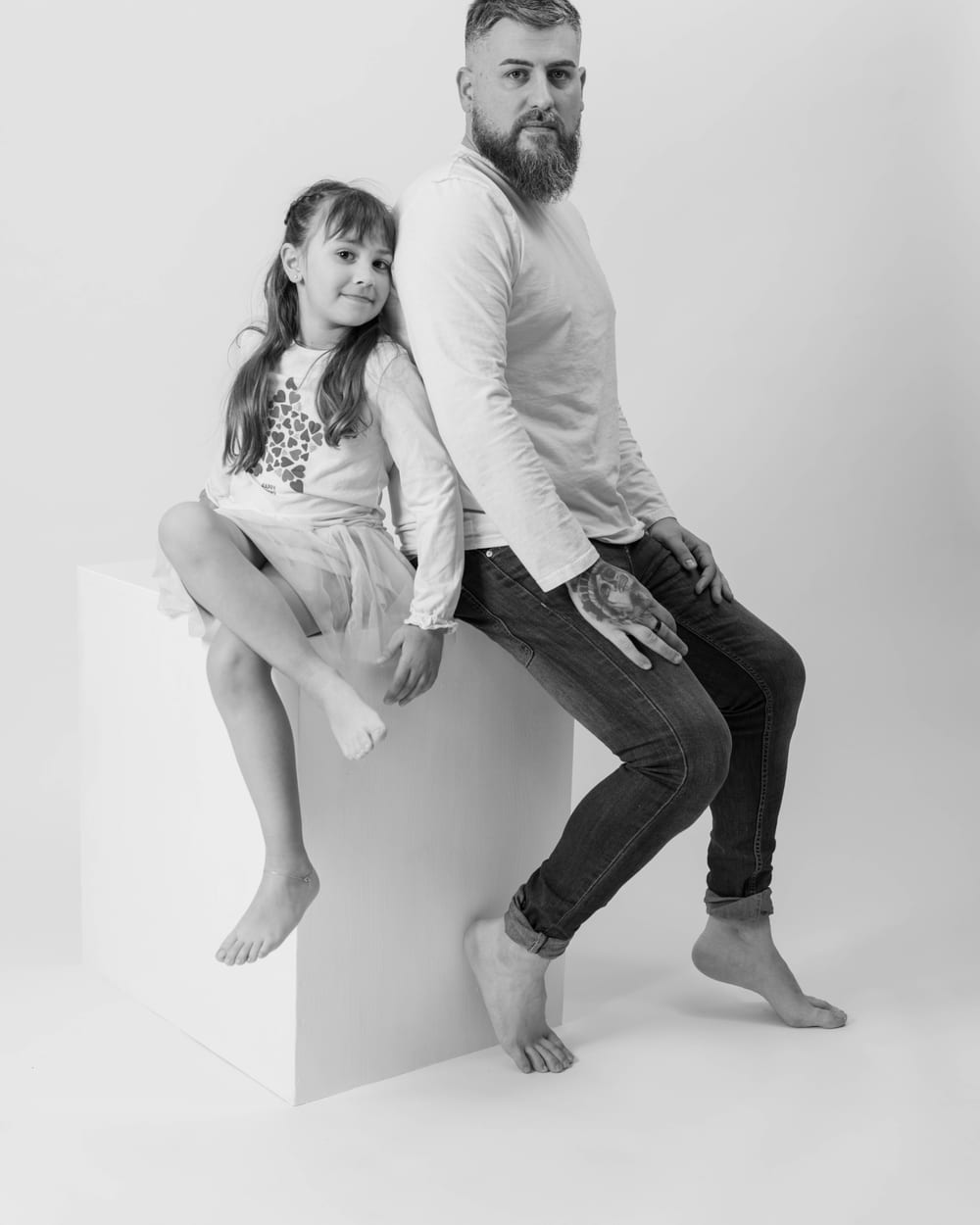 Pare i filla en una sessió de família en blanc i negre al plató · Objectiu Fotògrafs, Reus
