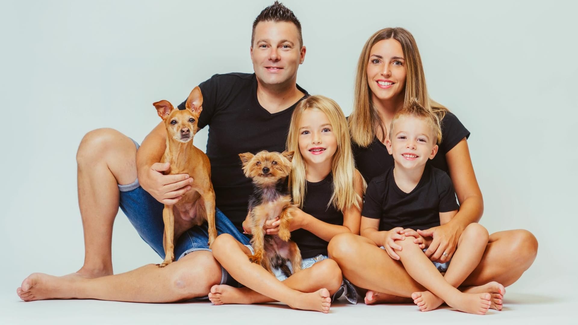 Família amb dos gossets asseguda a terra al plató · Objectiu Fotògrafs, Reus