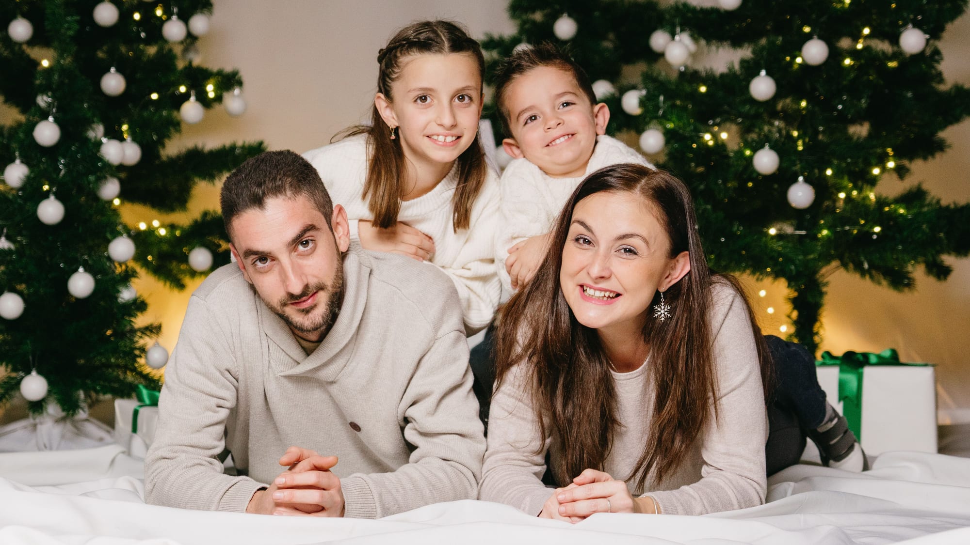 Família estirada davant dels arbres de Nadal al plató · Objectiu Fotògrafs, Reus