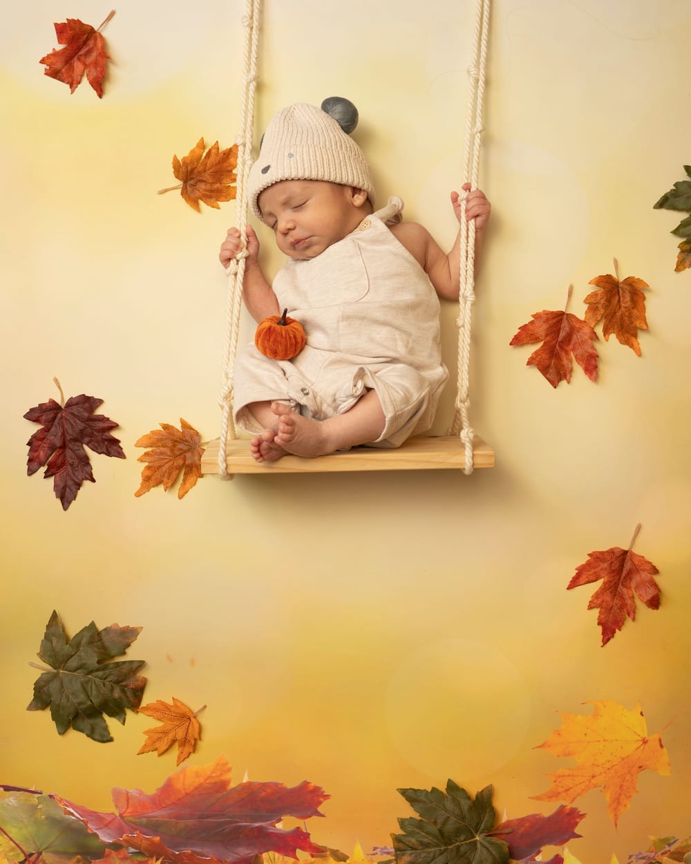 Bebé dormido en un columpio entre hojas de otoño · Objectiu Fotògrafs, Reus