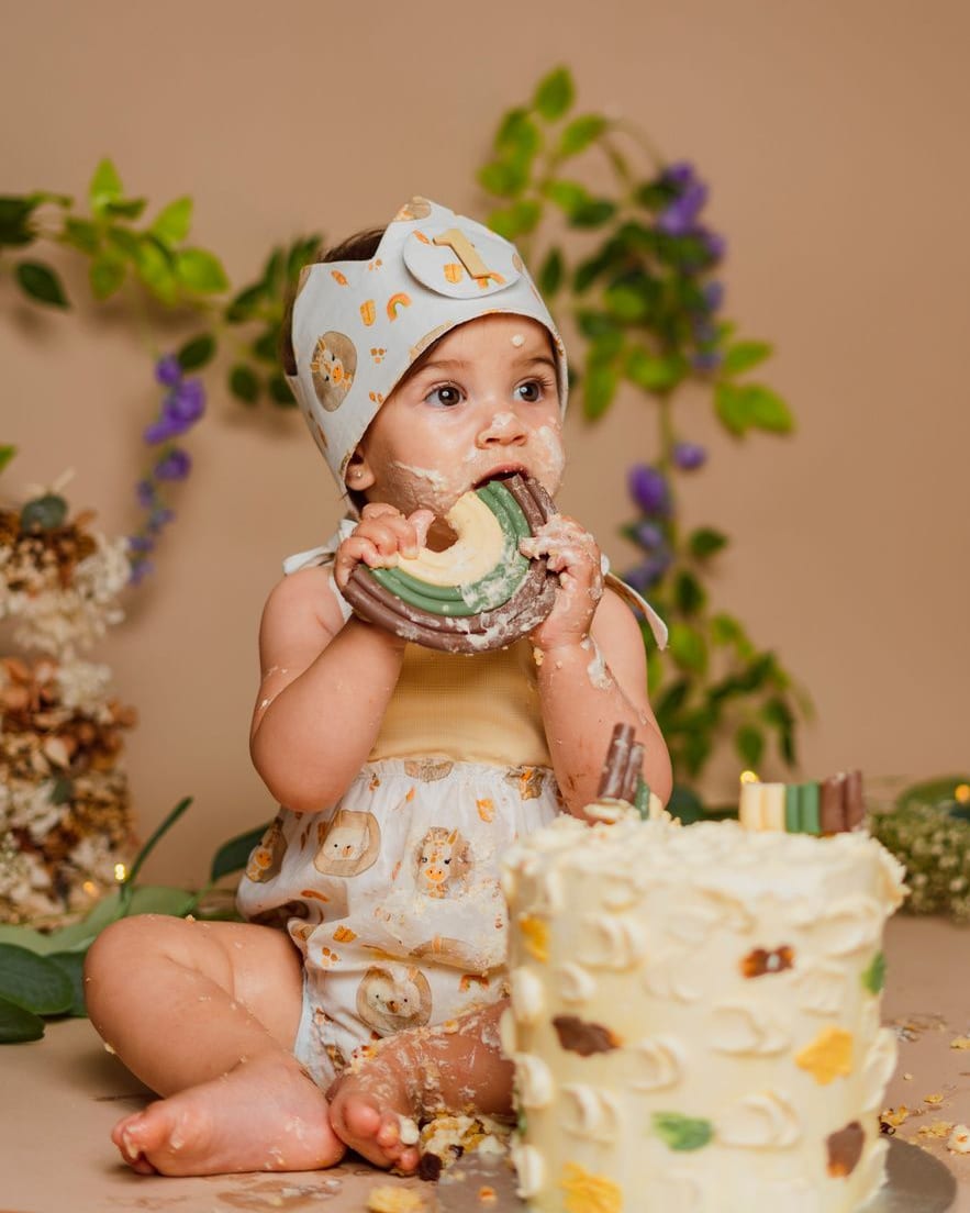 Bebé con corona comiéndose la tarta de cumpleaños en el plató · Objectiu Fotògrafs, Reus
